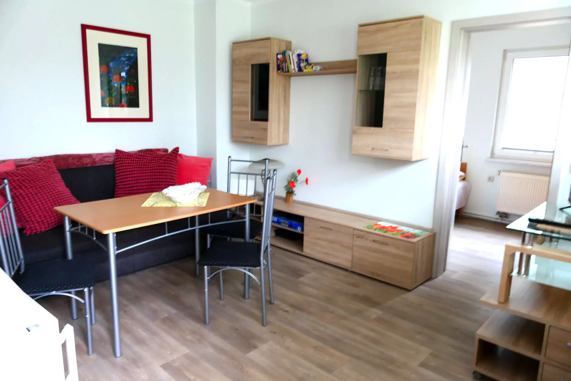 Gästehaus Roggenbuck - Familienzimmer mit 2 Räumen - Wohnbereich mit Sofa und Esstisch und Schlafzimmer