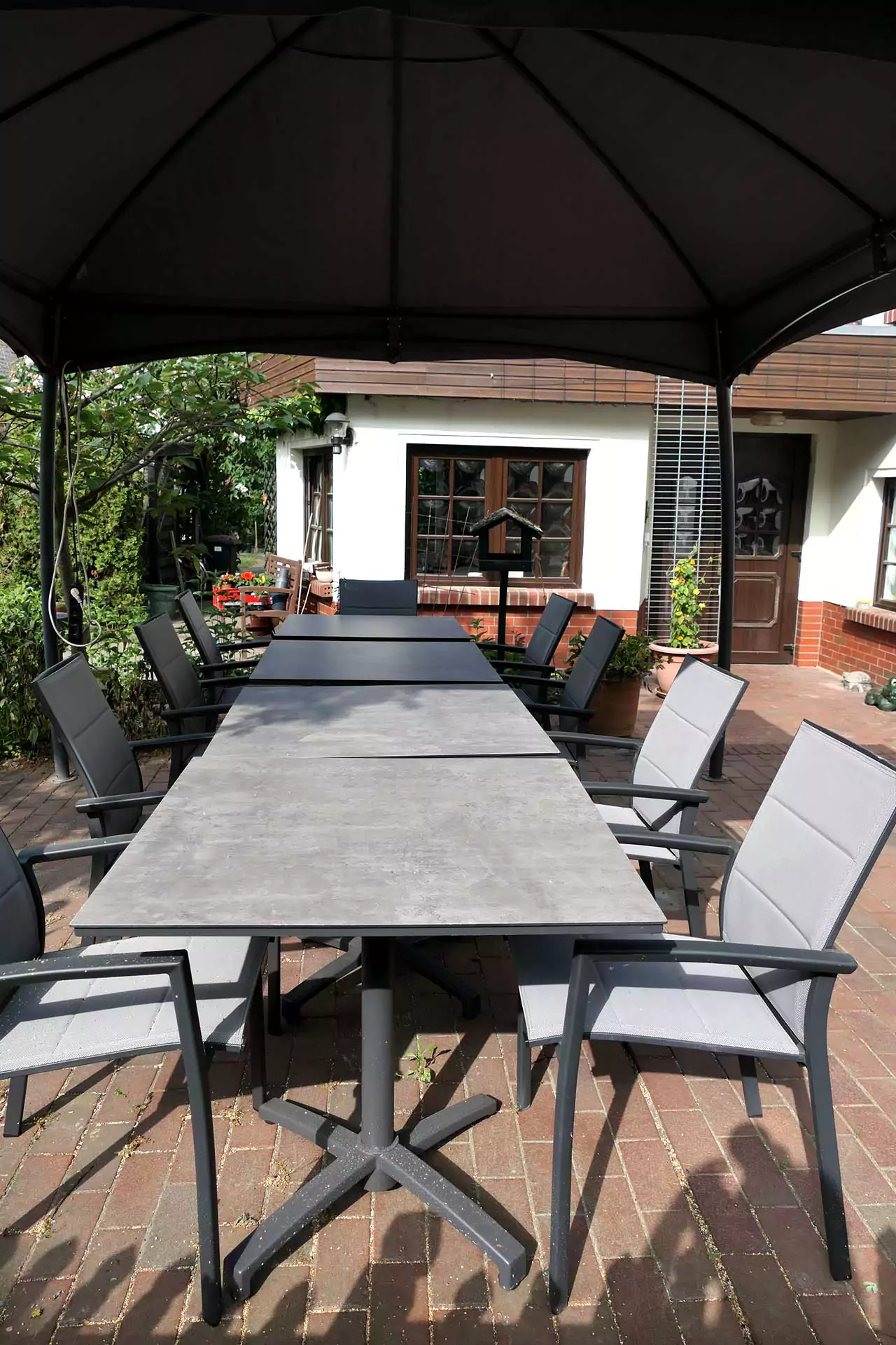 Gästehaus Roggenbuck - Terrassenbereich mit Tischen und Stühlen unterm vorm Gästehaus unterm Pavillon